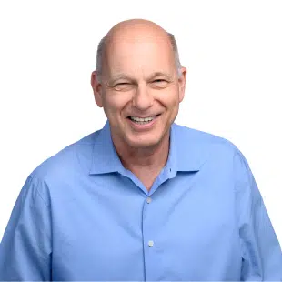 A bald man in a blue shirt smiling.
